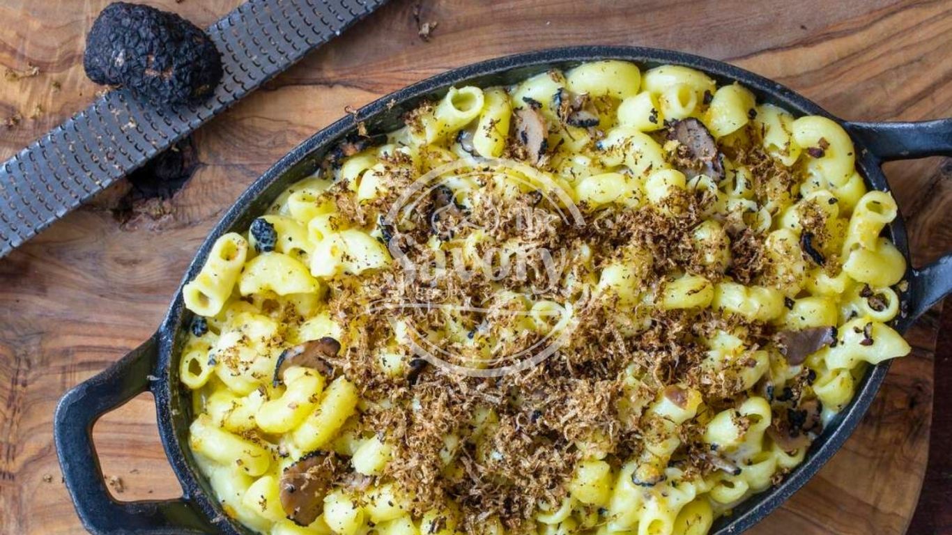 Breadcrumb topping being added to mac and cheese